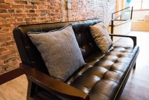 a leather couch in a room with a brick wall at Small Bridge Good Home in Tainan