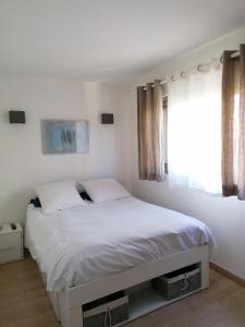 a bedroom with a white bed and a window at F3 tout equipe 5 min Croisette in Cannes