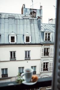 una taza de café sentada en el alféizar de la ventana en Arcadie Montparnasse en París