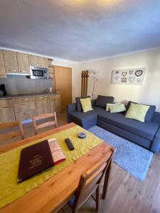 ein Wohnzimmer mit einem Tisch und einem blauen Sofa in der Unterkunft Haus Alpenrose in Waidring