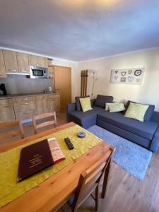 a living room with a table and a blue couch at Haus Alpenrose in Waidring