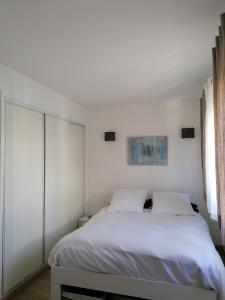 カンヌにあるF3 tout equipe 5 min Croisetteのベッドルーム(白いベッド1台、窓付)