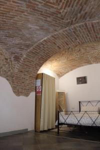 een kamer met een bakstenen plafond en een bed erin bij Bed&Braja in Vische