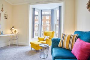 salon z niebieską kanapą i żółtym krzesłem w obiekcie Host & Stay - The Funky Robin w mieście Whitby
