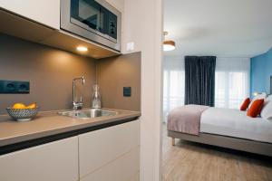 a kitchen with a sink and a bed in a room at Residhome Puteaux La défense in Puteaux