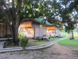 a building with a bench next to a tree at Emerald Gecko, Neil Island in Neil Island