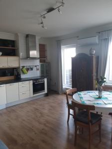 eine Küche mit einem Tisch, einem Tisch und Stühlen in der Unterkunft Apartment Stockerau in Stockerau