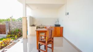 Sunburn Villa في نوسا دوا: مطبخ صغير مع طاولة خشبية وكاونتر