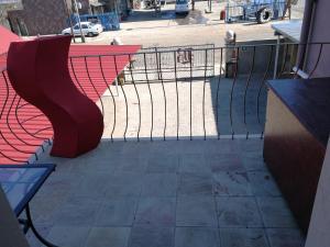 a red bench on a balcony next to a street at Bougain Villa Guesthouse in Winburg