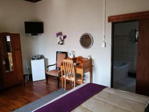 a bedroom with a desk and a room with a bed at Bougain Villa Guesthouse in Winburg