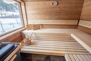 a sauna with a bench in a wooden room at Chalet's DAS DORF in Wald im Pinzgau