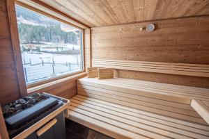 una sauna de madera con ventana y fogones en Chalet's DAS DORF en Wald im Pinzgau