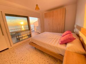 a bedroom with a bed with a view of the ocean at Agi Avenida Apartments in Roses