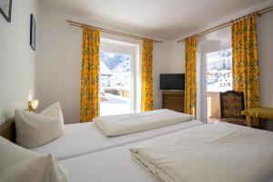 sypialnia z dwoma łóżkami i oknem w obiekcie Pension Nina & Gasthof Alpenrose w mieście Gschnitz