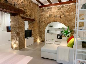 a living room with white furniture and a brick wall at Apto Toledo Medieval - Parking Gratis in Toledo