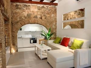 a living room with a white couch and a brick wall at Apto Toledo Medieval - Parking Gratis in Toledo
