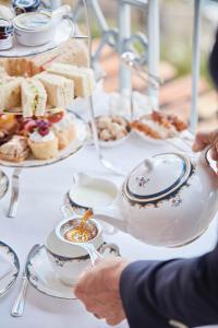 a table topped with plates and bowls of food at Reid's Palace, A Belmond Hotel, Madeira in Funchal