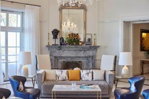 a living room with a couch and a fireplace at Reid's Palace, A Belmond Hotel, Madeira in Funchal
