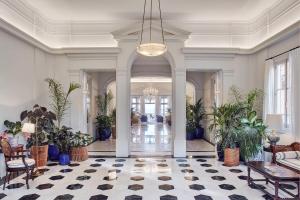 a large room with a lobby with plants and a chandelier at Reid's Palace, A Belmond Hotel, Madeira in Funchal