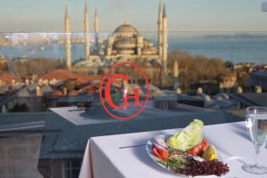 a plate of food on a table with a glass of wine at Deluxe Golden Horn Sultanahmet Hotel in Istanbul