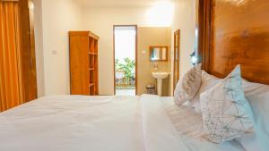 Sunburn Villa في نوسا دوا: غرفة نوم بسرير أبيض مع اللوح الخشبي