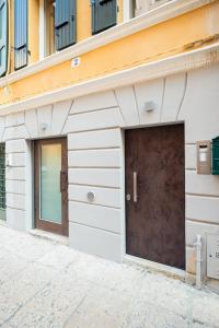 eine Garage mit brauner Tür an einem Gebäude in der Unterkunft Teatro Romano Easy Suites in Verona