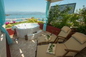 a patio with chairs and a hot tub on a balcony at Hotel Unique-Boutique Class - Adults Only in Fethiye