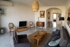uma sala de estar com um sofá e uma televisão em Les Sables - 75 m2 - 4 stars tourism Panoramic View em Antibes
