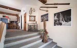 einen Flur mit Treppen und eine Wand mit Bildern in der Unterkunft Meublè Garnì Della Contea in Bormio