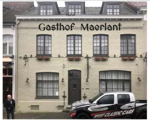 Gasthof Maerlant في دام: رجل يقف أمام مبنى فيه سيارة متوقفة أمامه