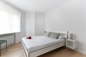 ein weißes Schlafzimmer mit einem Bett mit einem roten ausgestopften Tier darauf in der Unterkunft Piso recién reformado en el centro de Pamplona in Pamplona