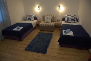 ein kleines Zimmer mit 2 Betten und einem Sofa in der Unterkunft Apartments Vila Mileva in Rava