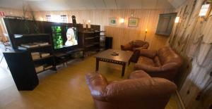 a living room with leather furniture and a television at Ulvö Lakeside Resort in Ulvöhamn