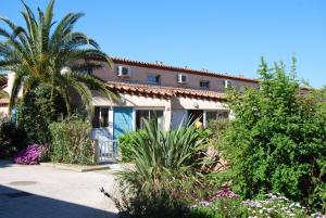 a house with a palm tree and some plants at Lagrange Grand Bleu Vacances – Résidence Les Jardins de Neptune in Saint-Cyprien