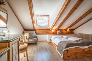 une chambre avec un lit et une chaise dans un grenier dans l'établissement Hotel Resort Veronza, à Cavalese 37 autres photos