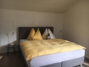 een bed met gele lakens en kussens in een slaapkamer bij Haus ALPENBLICK in Malta