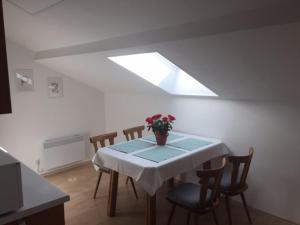 a dining room with a table with a vase of flowers on it at Haus ALPENBLICK in Malta