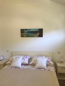 a bed with two pillows and a picture on the wall at studio apartment near the beach-Ilda Radonic in Jelsa