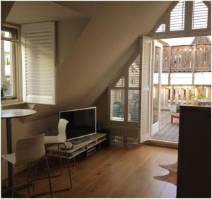 a living room with a television and a table and chairs at Prince On The Roof in Amsterdam