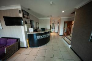 a lobby of a hotel with a reception counter at Berwick Manor Hotel in Rainham