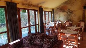- un salon avec des tables, des chaises et un canapé dans l'établissement Villa Del Arte Bed & Breakfast, à Wadowice