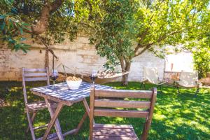 een tafel en twee stoelen met wijnglazen erop bij Trullieu Guesthouse Alberobello in Alberobello