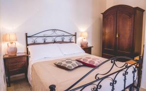 a bedroom with a large bed with two night stands at Trullieu Guesthouse Alberobello in Alberobello