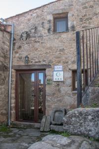 un edificio de piedra con una puerta y un cartel en él en Casa Rural La Pastera, en Trevejo