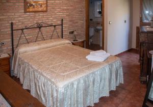Casa Rural La Pastera في Trevejo: غرفة نوم بسرير وجدار من الطوب
