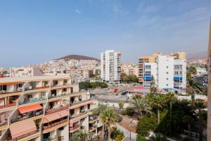a city with tall buildings and palm trees at First line sea, luxury penthouse, sea and sunset view Vivenda Vacational Guayero 618 in Los Cristianos