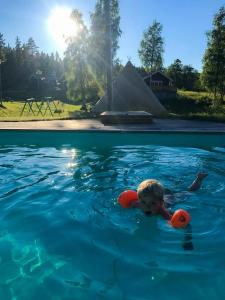 a young boy swimming in a swimming pool at Ulvö Lakeside Resort in Ulvöhamn
