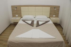 una camera da letto con un grande letto con due tavoli di Casa Hena a Ulcinj