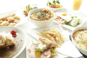 una mesa llena de diferentes tipos de comida en platos en Hotel Mio (Adult Only), en Kariya