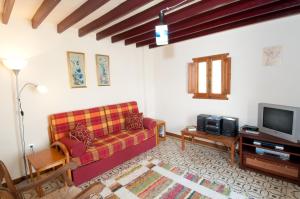 een woonkamer met een bank en een tv bij El Cortijo at Molino la Ratonera in Zagra